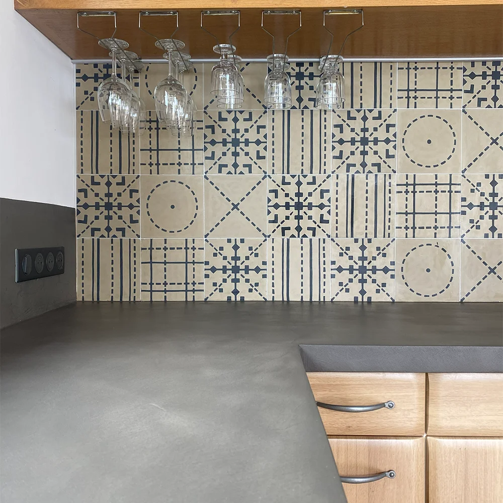 Plan de travail en béton ciré gris avec verres suspendus, créé par Altmeyer dans le Var, pour une cuisine contemporaine et fonctionnelle.