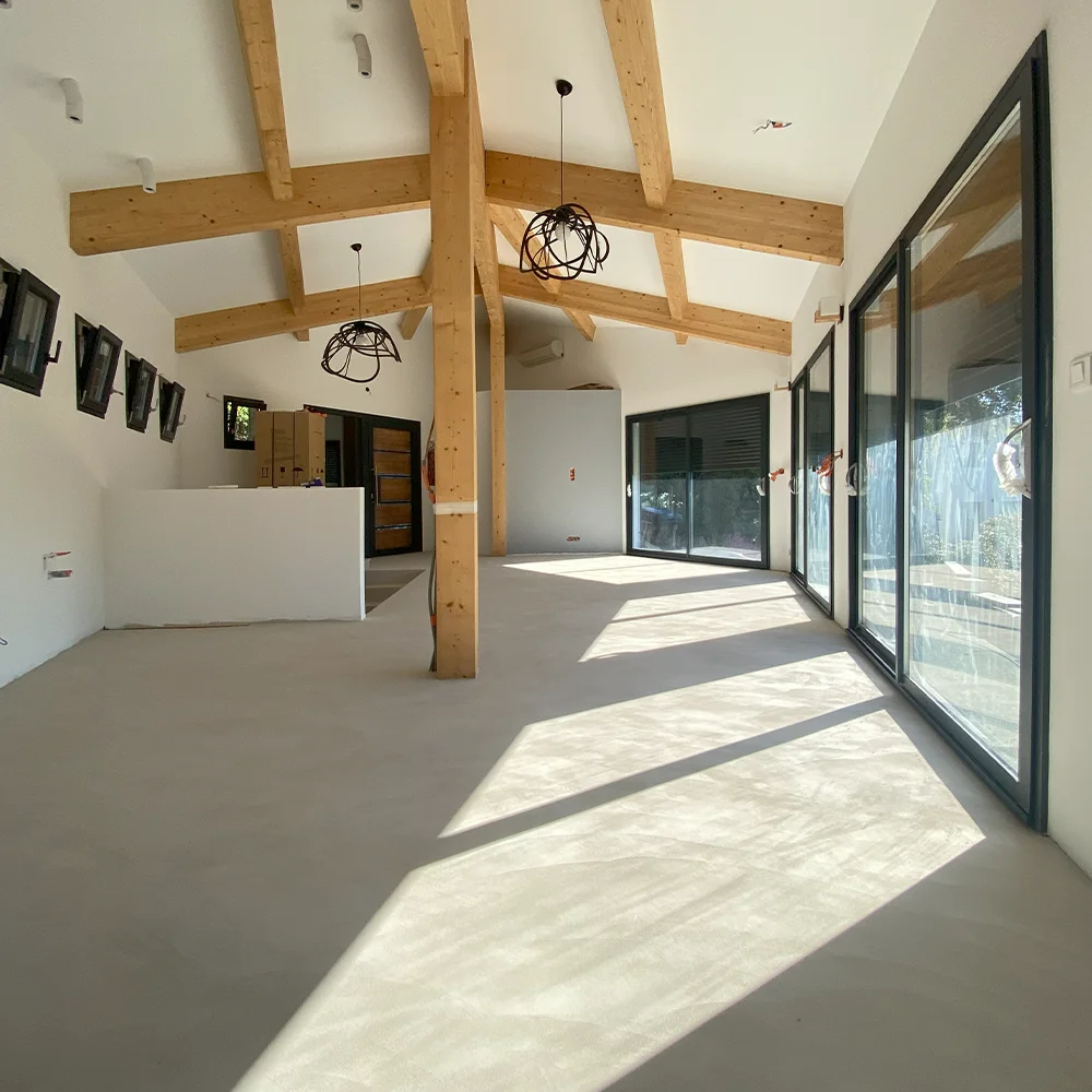 Sol en béton ciré pour une grande pièce, signé Altmeyer, dans le sud du Var, offrant un design moderne et élégant.